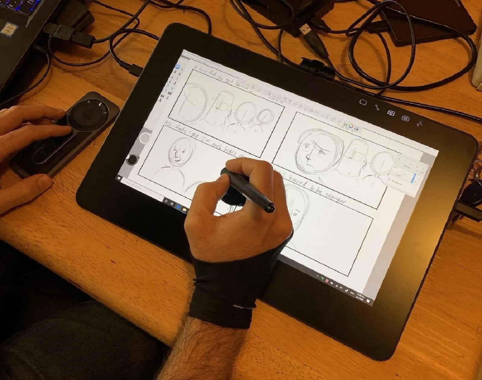 A hand drawing storyboard panels on a pen tablet.